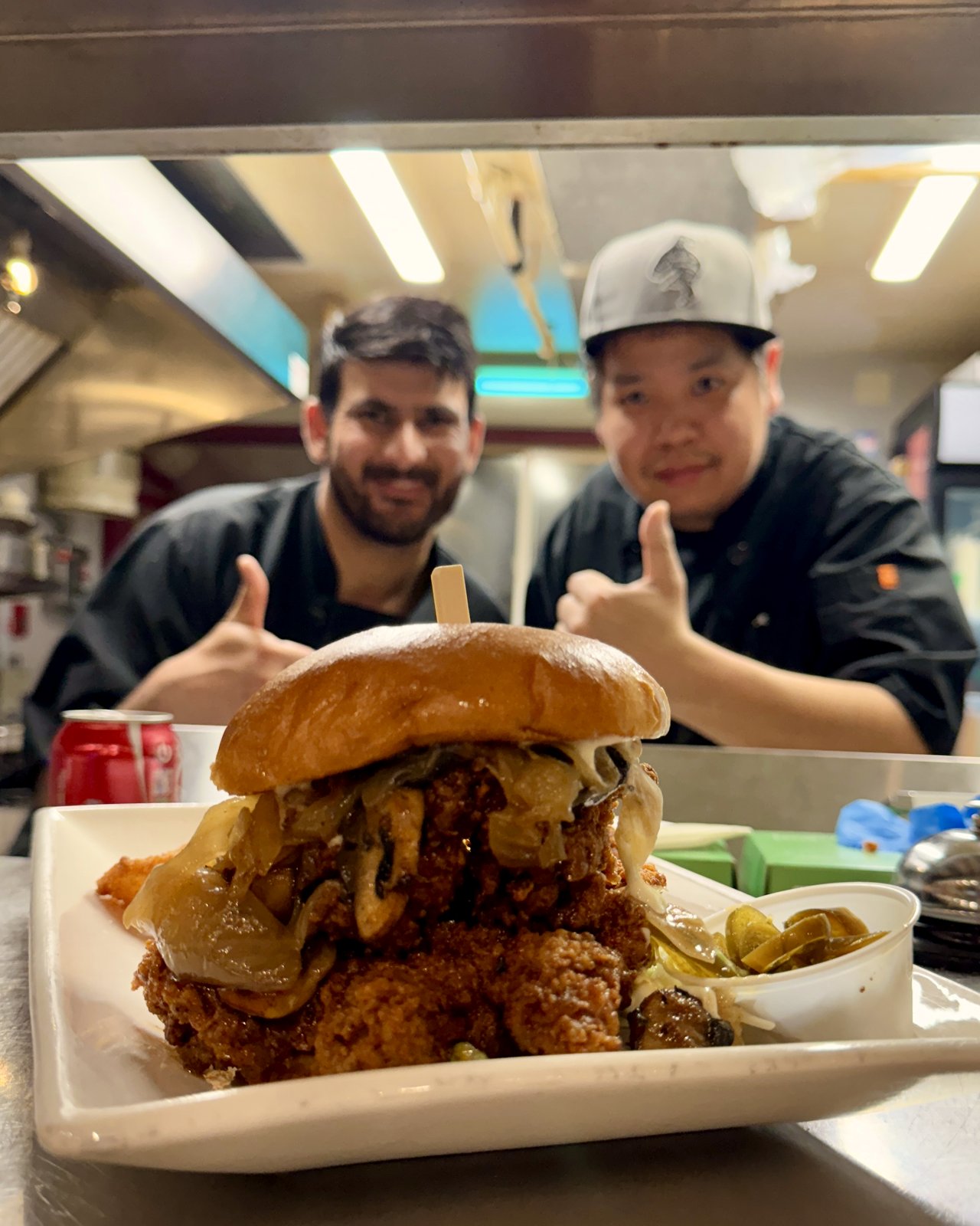 OV Burger Bar kitchen team thumbs up at the pass with a Mt Olympus fried chicken sandwich, OV Burger Bar Prince Rupert