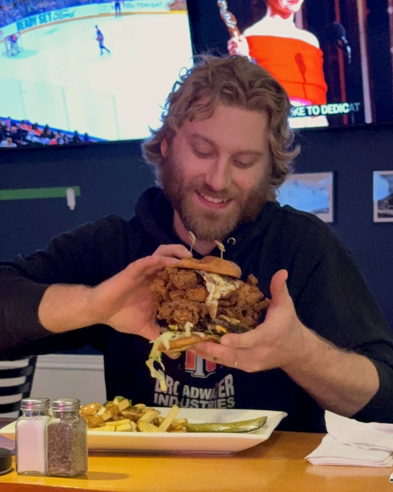 Guest enjoying the Mt Olympus fried chicken sandwich on hockey night at OV Burger Bar Prince Rupert